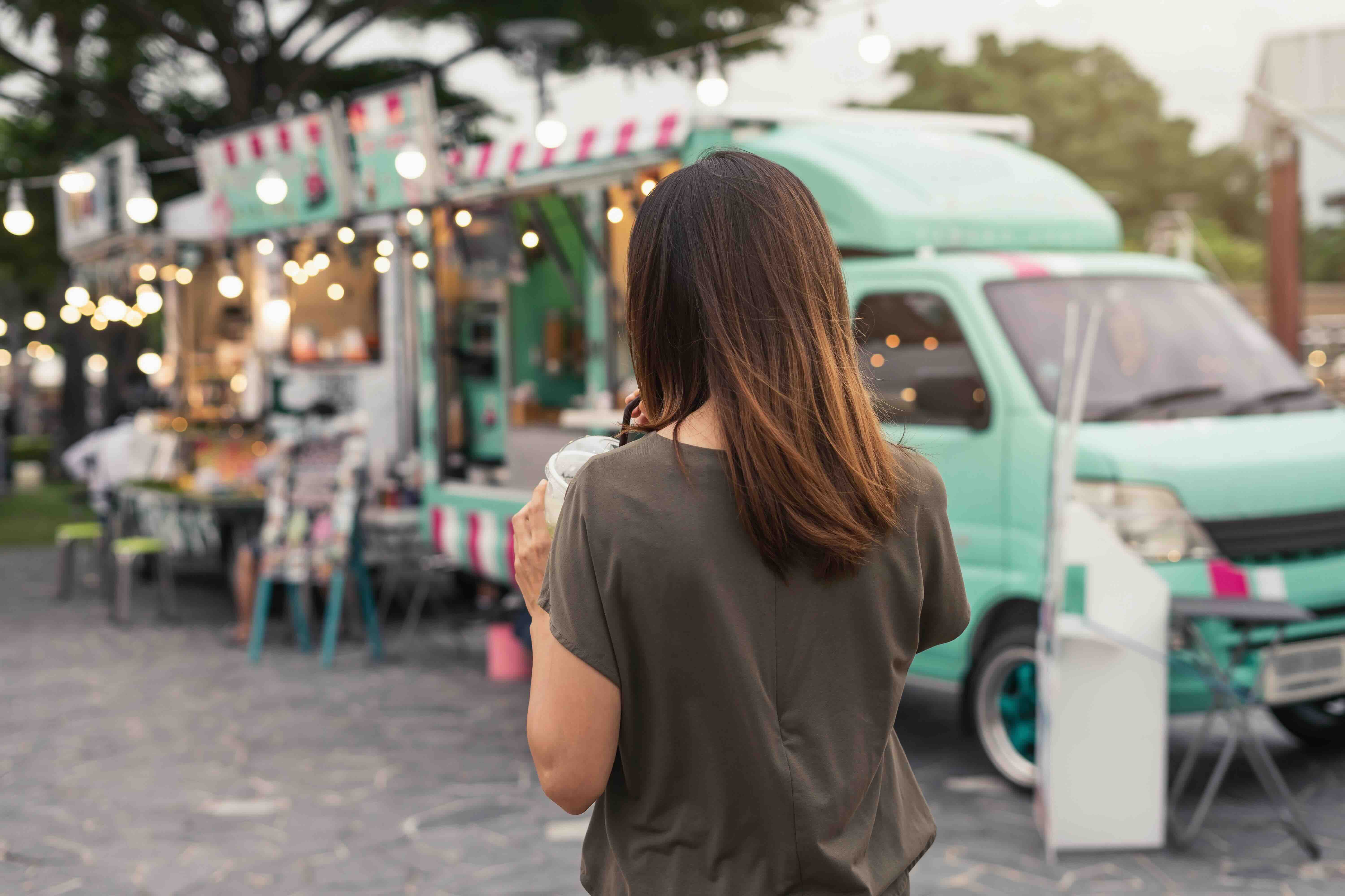 Young Asian Woman Walking In The Food Truck Market