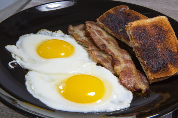 Breakfast Plate Sunny Side Up Fried Eggs Bacon Strips And Burnt Toast