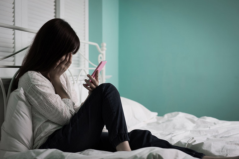 80029713 Woman Feel Depression And Look Phone Sit On The Bed