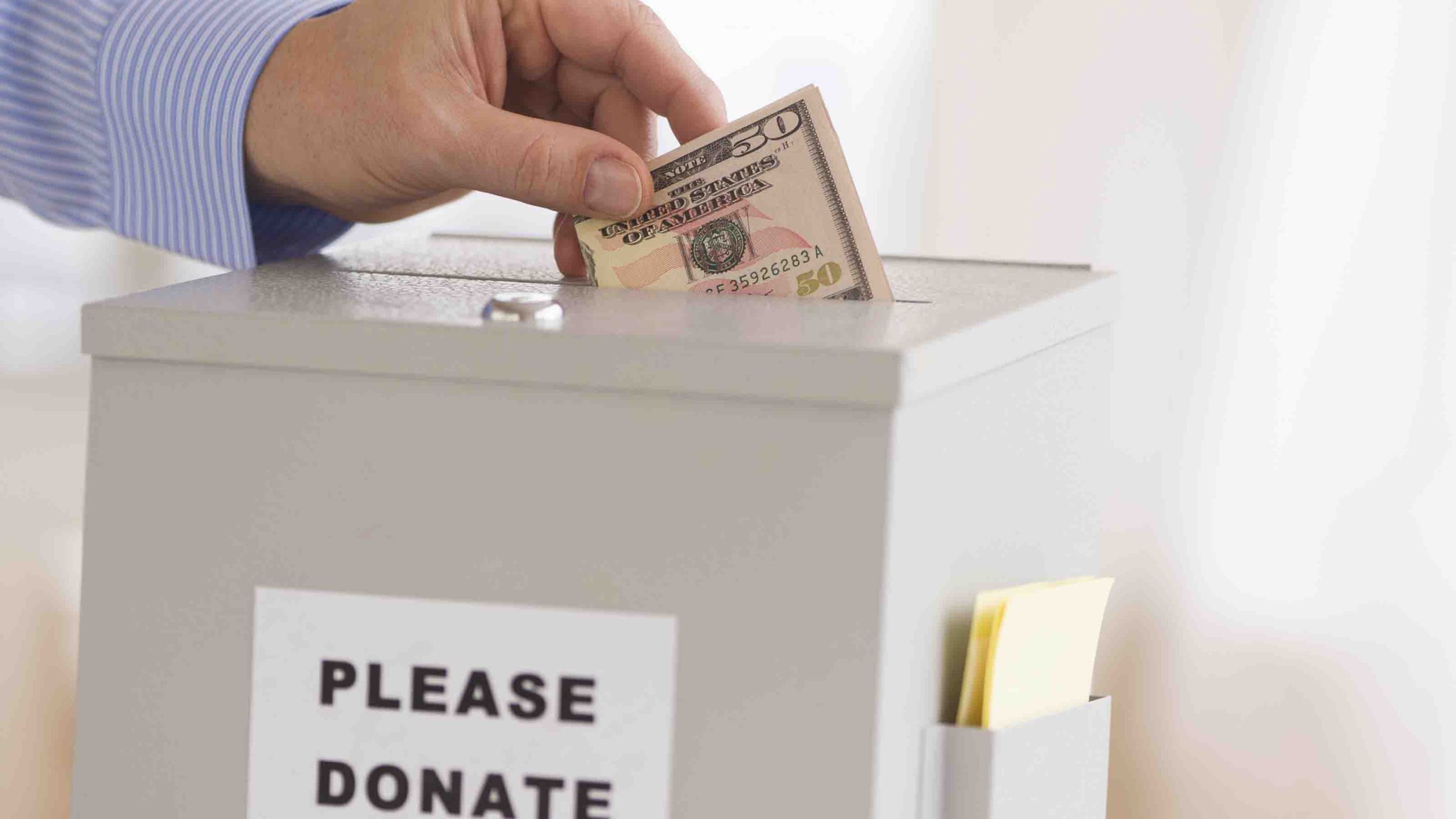 Jersey City, New Jersey, Man's Hand  Putting Dollars Into Donation Box