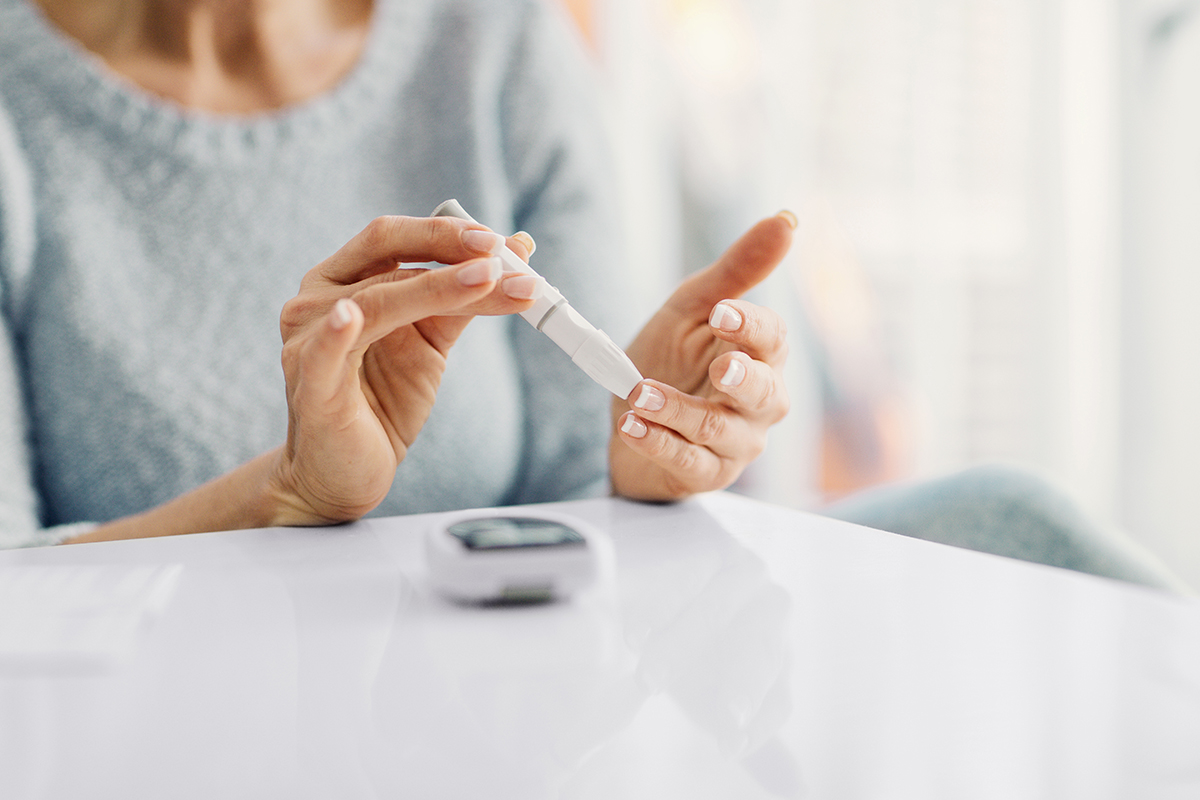 Mature Woman Doing Blood Sugar Test At Home.