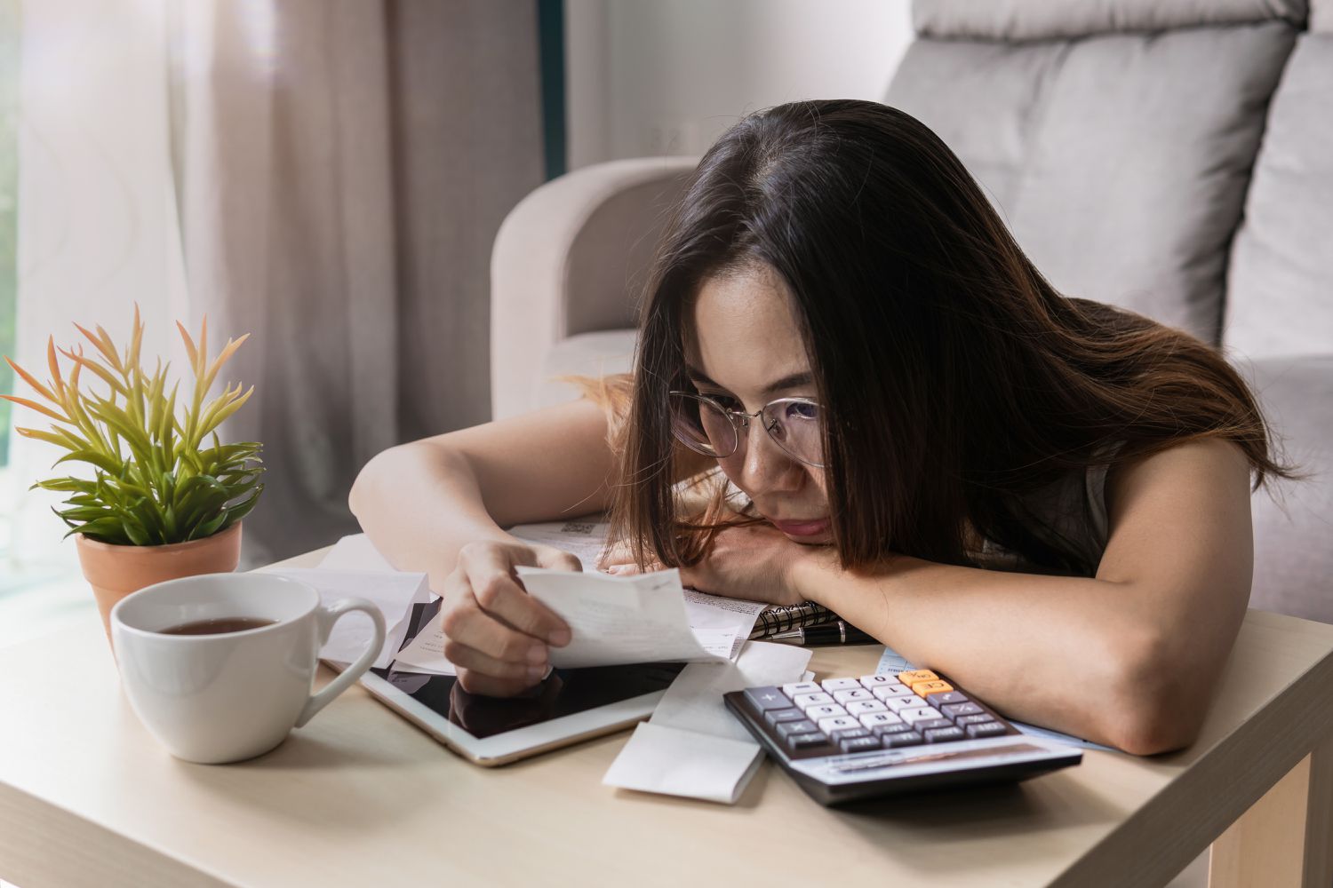 Sad Woman Looking At Financial Bill On Table 1160169605 D5fb800e6194492db7e04cd2b86872d9