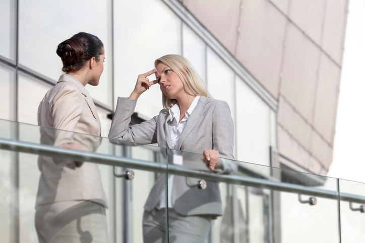 Young Businesswoman Arguing With Female Colleague At Office Railing