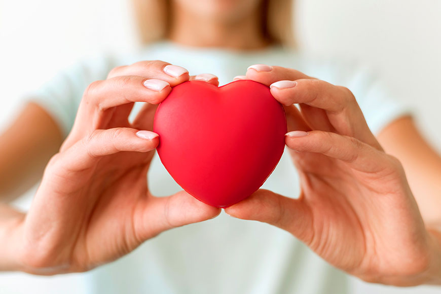 Defocused Woman Holding Heart Shape