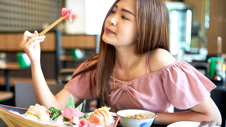 Beautiful,Asian,Woman,Eating,Sashimi,,Japanese,Food.