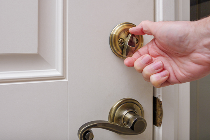 A Close Up Of A Homeowner Turning A Night Latch