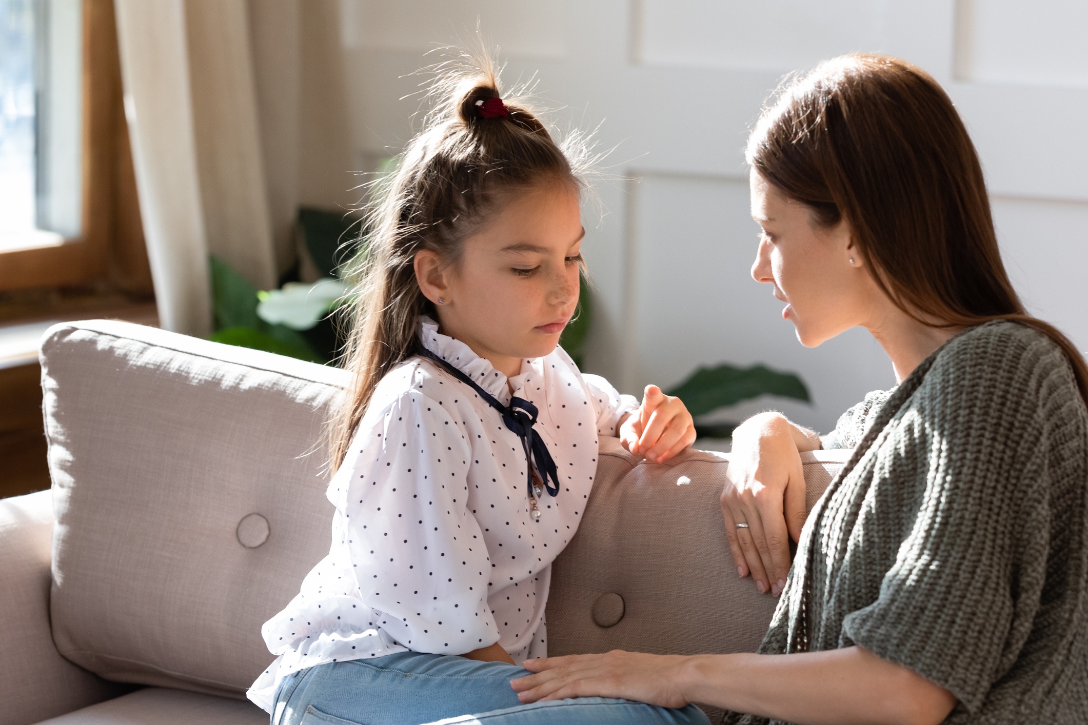 Upset Small Schoolgirl Having Trustful Conversation With Mother.