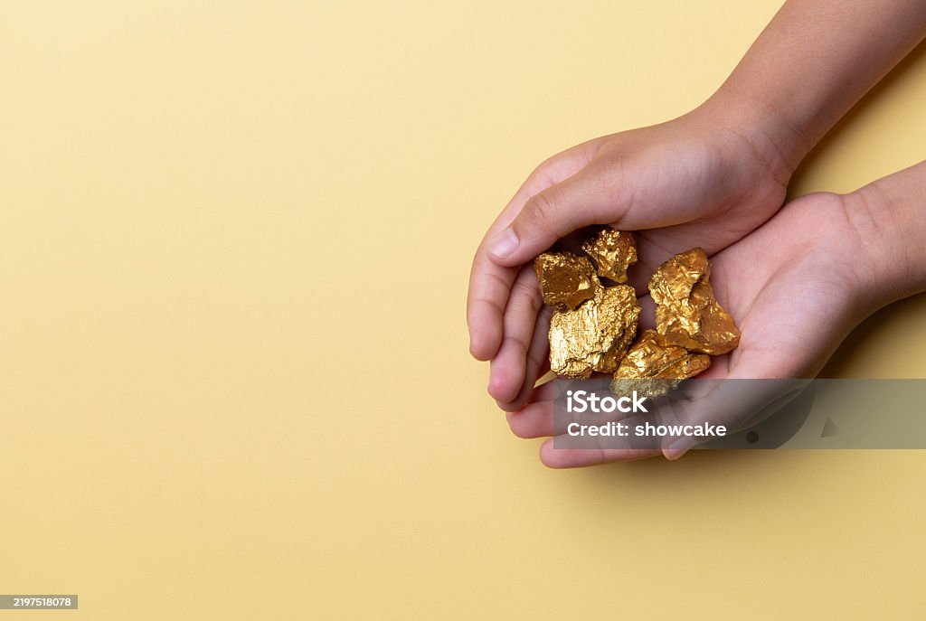 Hands Holding Soil And Gold Nuggets On Yellow Background